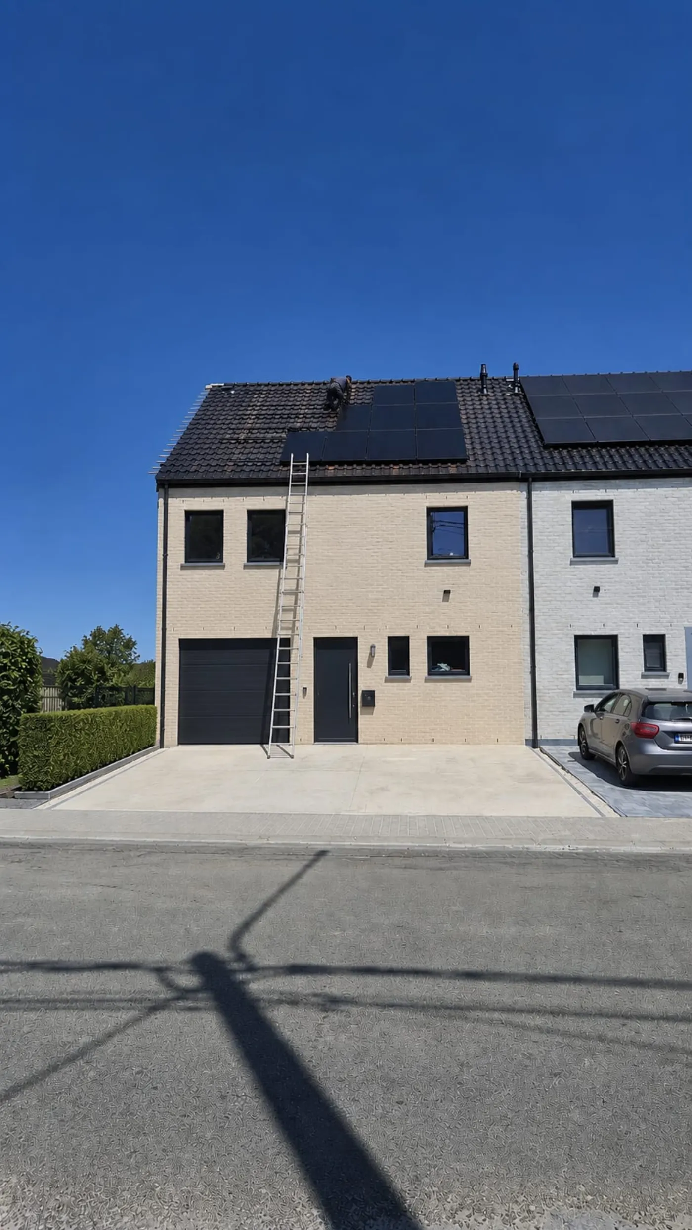 Pose de panneaux photovoltaïques full black sur toiture en tuiles à Soignies, échelle de couvreur en place pendant l'installation par ElectriPilar