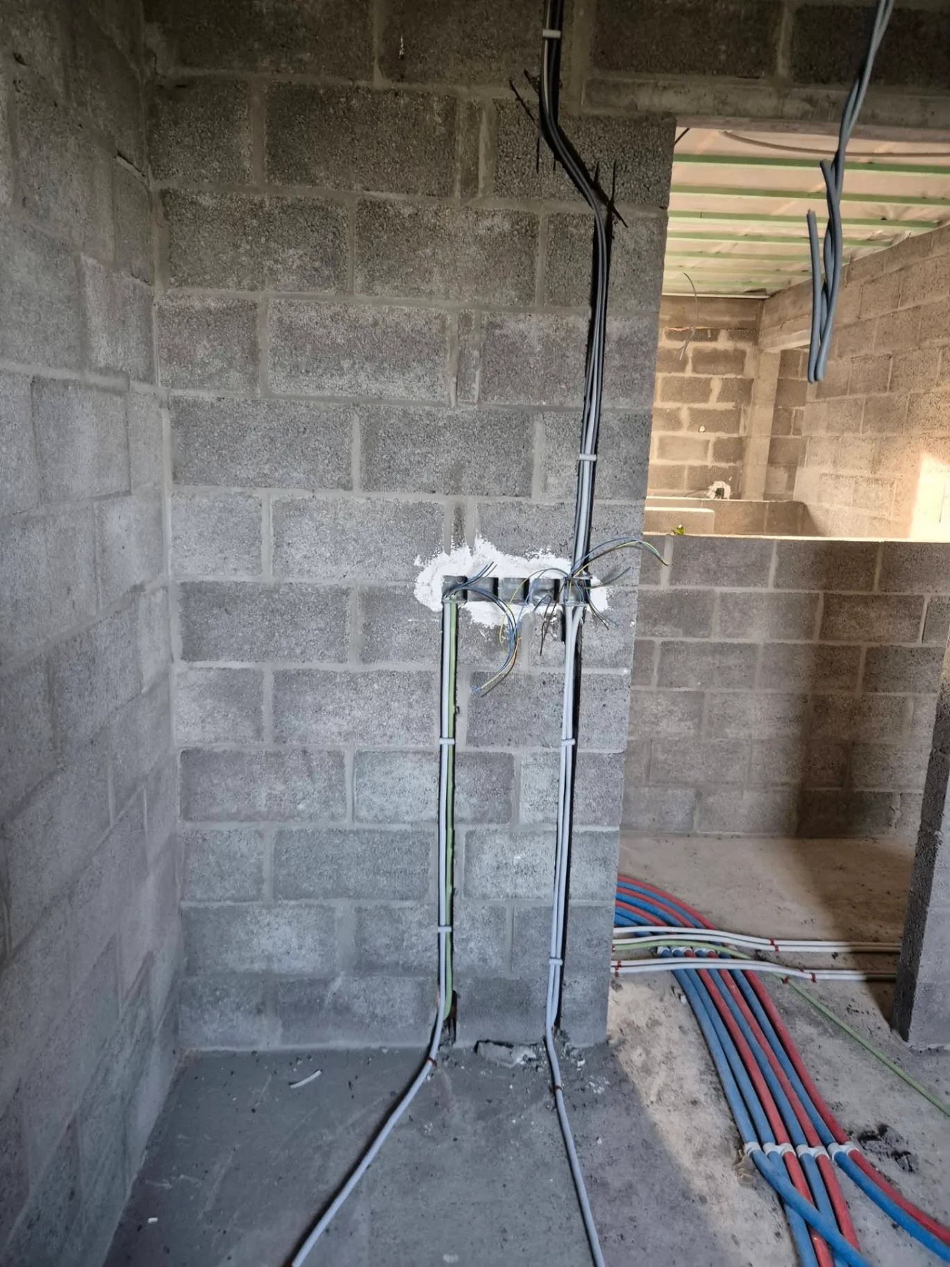 Boîtier de dérivation et arrivées de câbles dans un mur de cellulaire à Ath