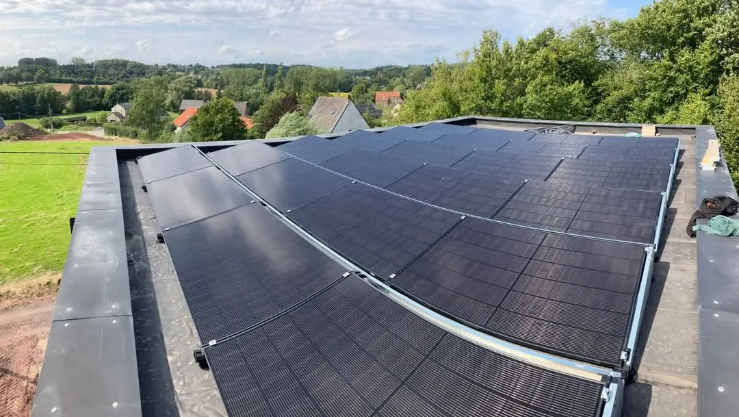 Installation photovoltaïque sur toiture plate à Soignies, modules full black sur bacs lestés avec vue panoramique sur la campagne du Hainaut