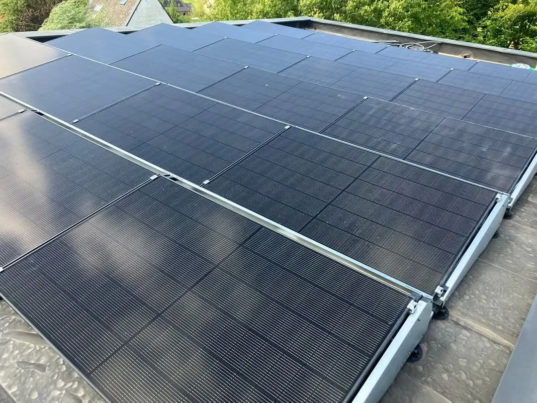 Champ photovoltaïque sur toiture plate à Soignies, modules full black inclinés sur bacs lestés est-ouest pour maximiser l'autoconsommation