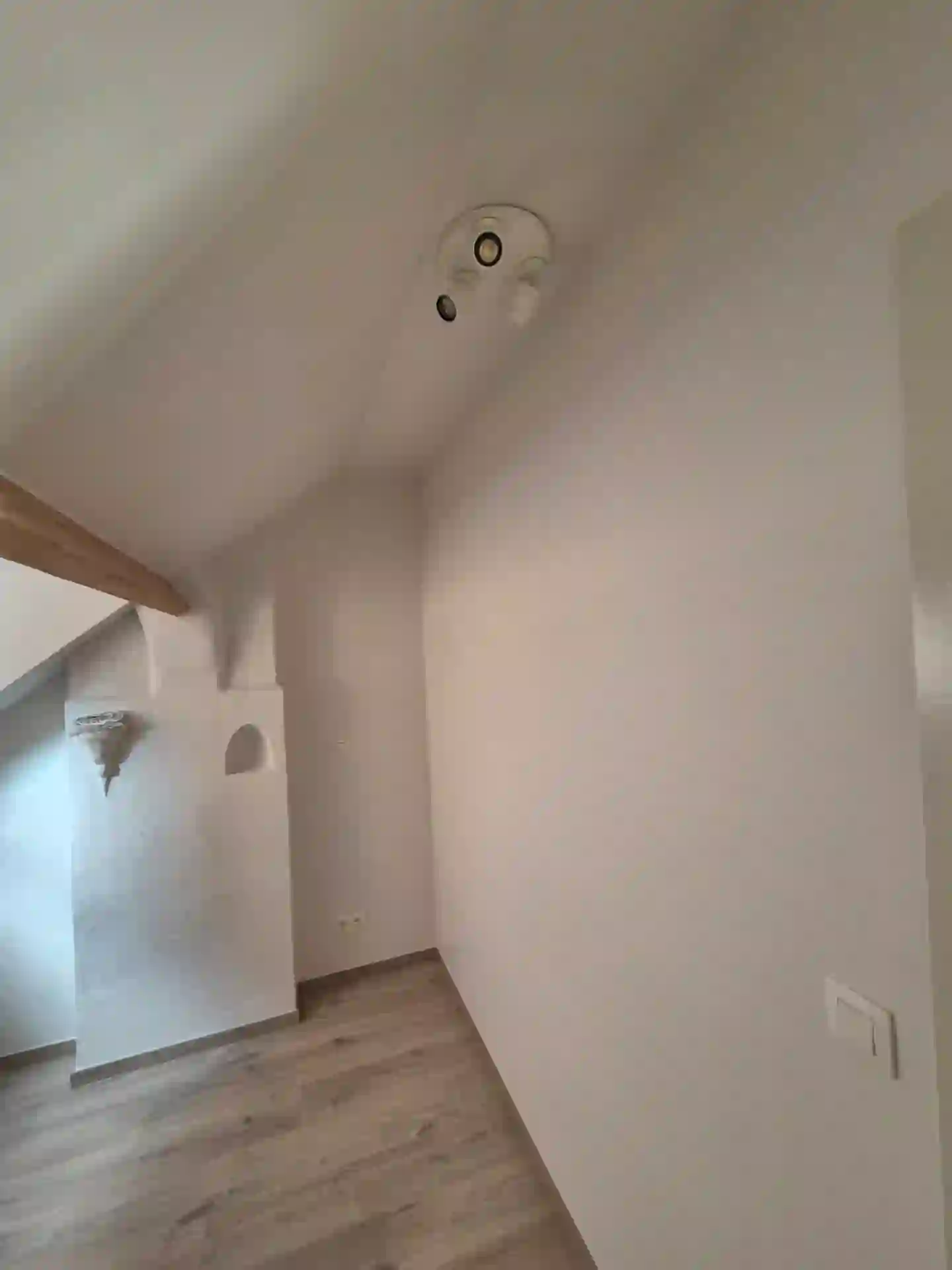 Point lumineux et finitions électriques en plafond incliné dans une maison à Soignies