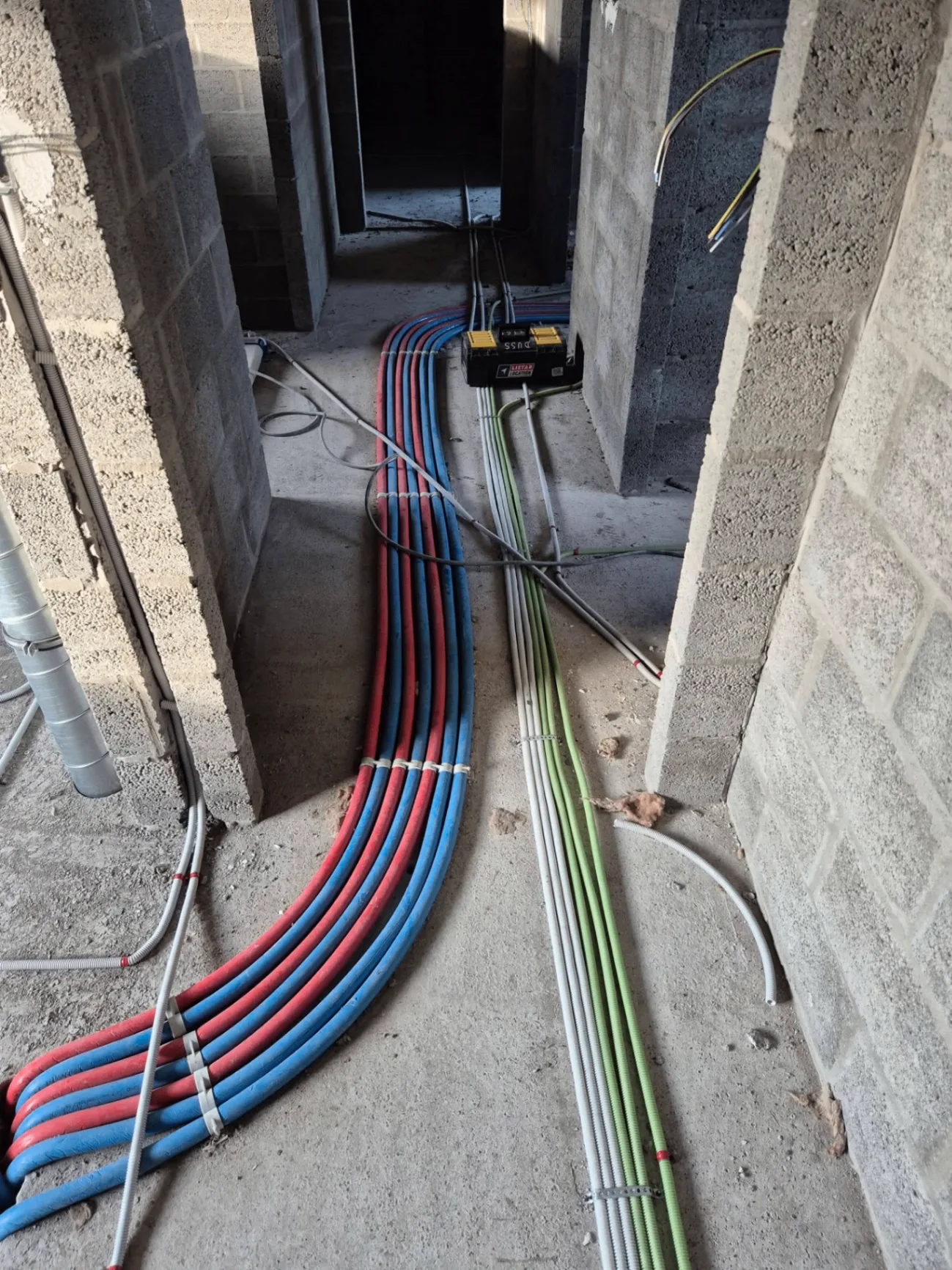 Passage des câbles PER et électriques entre les pièces d'une maison neuve à Ath